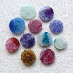May include: Twelve round agate slices in various colors, including blue, purple, pink, red, and green. The slices are all about 1 inch in diameter and have a natural, polished finish.