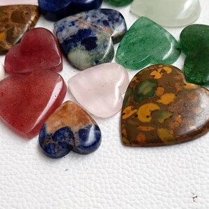 May include: Assortment of heart-shaped polished stones in various colors, including red, green, blue, brown, and pink. The stones are smooth and have a natural, polished finish.