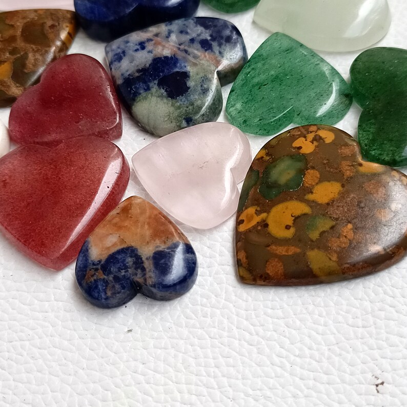 May include: Assortment of heart-shaped polished stones in various colors, including red, green, blue, brown, and pink. The stones are smooth and have a natural, polished finish.