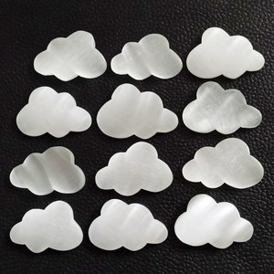 Peut inclure: Douze pierres en forme de nuage de sélénite blanche. Les pierres sont lisses et ont un léger éclat iridescent.