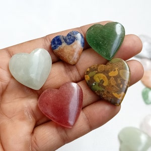 May include: Six heart-shaped polished stones in various colors and patterns. The stones are green, brown with yellow and green flecks, light green, red, and blue with white and orange.