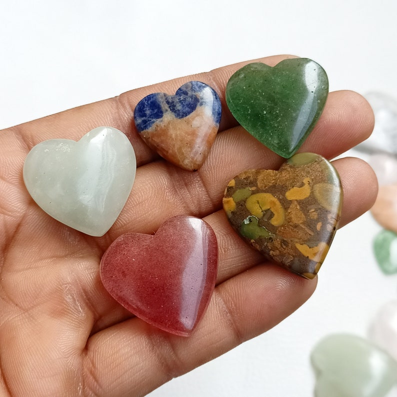 May include: Six heart-shaped polished stones in various colors and patterns. The stones are green, brown with yellow and green flecks, light green, red, and blue with white and orange.