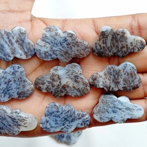 May include: A collection of nine cloud-shaped agate cabochons with a white base and brown dendritic patterns. The cabochons are smooth and polished.