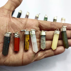 May include: Assortment of 10 crystal point pendants with silver caps. The crystals are in various colours, including black, red, brown, white, clear, and green.