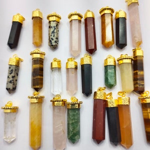 May include: Assortment of 20 gold-capped crystal point pendants. The pendants are made of various types of stones, including clear quartz, rose quartz, tiger's eye, and aventurine. The pendants are all approximately the same size and shape, and they are all strung on a gold chain.