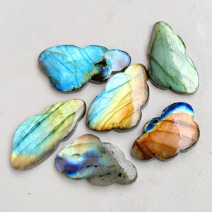 May include: Six iridescent labradorite gemstone cabochons in various shades of blue, green, gold, and brown. The cabochons are shaped like irregular clouds.