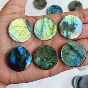 May include: A collection of eight round labradorite gemstone cabochons, each with a unique iridescent sheen. The stones range in color from green to blue to gold, with a variety of patterns and textures.