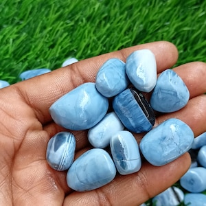 May include: A collection of blue and white tumbled stones. The stones are smooth and have a variety of patterns.