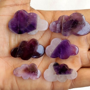 May include: Six purple amethyst cloud shaped crystal stones. The stones are polished and have a smooth, shiny finish.