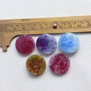 May include: Six round agate slices in various colors, including pink, purple, blue, and brown. The agate slices are approximately 1 inch in diameter.