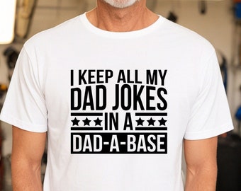 May include: White t-shirt with black text that reads "I keep all my dad jokes in a dad-a-base".
