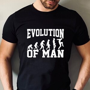 May include: A black t-shirt with a white graphic of the evolution of man, with the text "EVOLUTION OF MAN".