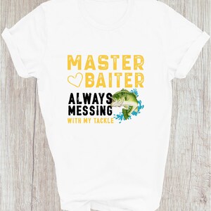 May include: White t-shirt with the text "MASTER BAITER" in yellow, a heart, and the words "ALWAYS MESSING WITH MY TACKLE" in black. A green and white fish graphic is included.