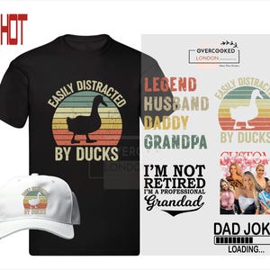 K&ouml;nnte beinhalten: Ein schwarzes T-Shirt mit einer Grafik im Vintage-Stil, auf dem "Easily Distracted by Ducks" steht. Die Grafik zeigt eine Ente vor einem Sonnenuntergang. Das Shirt tr&auml;gt au&szlig;erdem den Text "Legend Husband Daddy Grandpa" und "I'm Not Retired I'm a Professional Grandad".