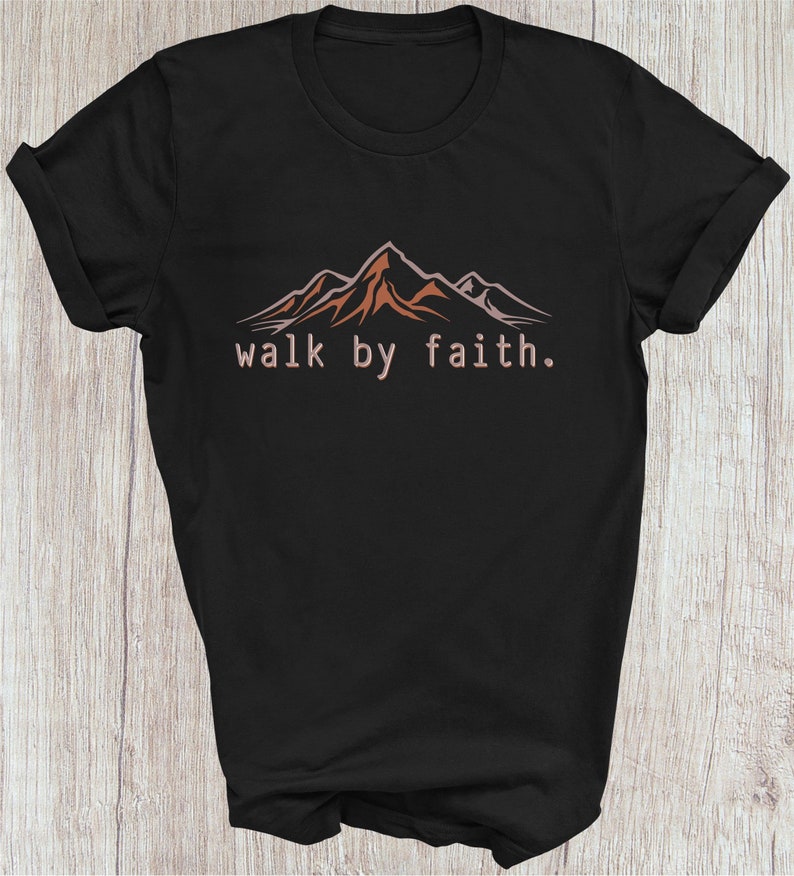Peut inclure: T-shirt noir avec un motif de cha&icirc;ne de montagnes et le texte "walk by faith."