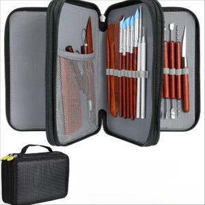 May include: A black zipped case containing a set of sculpting tools. The tools include wooden and metal instruments with various blade shapes and blue-tipped tools. A smaller black case with a handle is also visible.