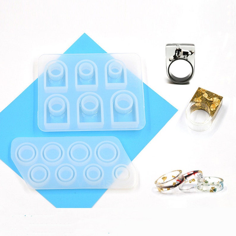 May include: Two silicone molds for making resin rings. One mold has six rectangular ring slots, and the other mold has eight round ring slots.