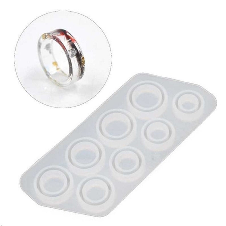 May include: A clear silicone mold with eight ring-shaped cavities. The mold is designed for making resin rings.