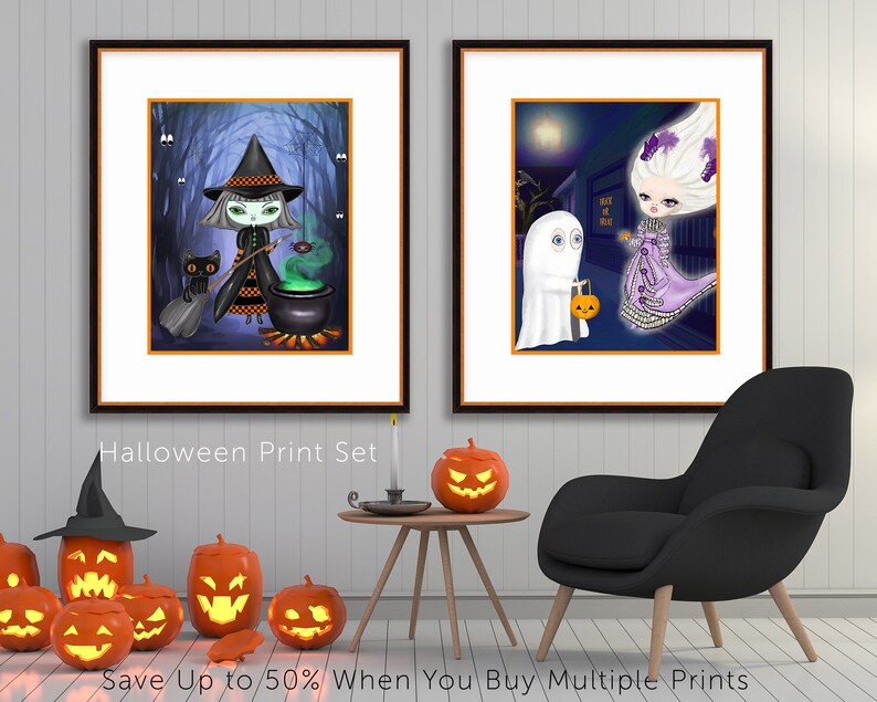 Pu&ograve; includere: Due stampe di Halloween incorniciate. Una raffigura una strega che mescola un calderone con un gatto nero e un ragno. L'altra mostra un fantasma che fa dolcetto o scherzetto con una figura in costume. Il testo "Halloween Print Set" &egrave; visibile.