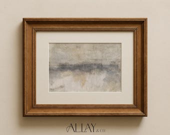 May include: A rectangular wall art piece in a medium brown wooden frame with a cream-colored mat board. The artwork features an abstract landscape with muted gray, beige, and white tones. Text below reads ALLAY & CO. FOR HOMES THAT FEEL COLLECTED, NOT DECORATED.