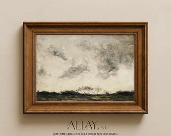 May include: A landscape painting in a dark wood frame featuring a cloudy, grey sky above a dark, textured horizon line. The artwork displays a small crescent moon in the upper left corner. Below the frame, the text reads ALLAY & CO. FOR HOMES THAT FEEL COLLECTED, NOT DECORATED.