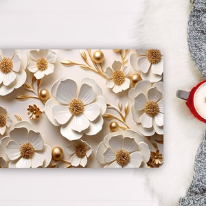 May include: A laptop skin with a white background and a pattern of white paper flowers with gold centers and gold accents. The flowers are arranged in a random pattern and overlap each other.