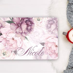 Puede incluir: Una pegatina rectangular para portátil con un estampado floral de grandes peonías superpuestas en tonos rosa empolvado, malva y blanco. El nombre Nicole está impreso en una elegante letra cursiva de color morado oscuro en la parte inferior derecha.