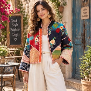 May include: A cropped jacket featuring a patchwork design with various floral and paisley patterns in red, blue, green, and yellow. The jacket has long sleeves, a round neckline, and a white and red striped trim along the front opening and cuffs.
