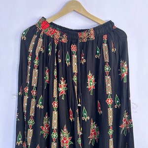 May include: A black skirt with a floral print and beaded embellishments. The skirt has an elastic waistband and a drawstring closure.