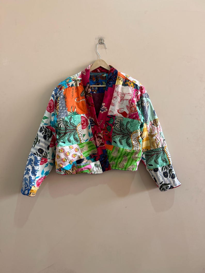 May include: A patchwork jacket with a vibrant mix of colors and patterns. The jacket features a V-neck design and long sleeves. The fabric is a combination of floral, animal, and geometric prints in shades of red, orange, green, and blue.