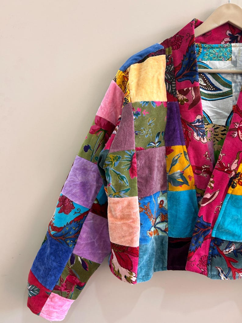 May include: A patchwork jacket with a vibrant mix of colors and patterns. The jacket features a variety of fabrics, including velvet, in shades of pink, blue, purple, yellow, and green. Floral and geometric designs are incorporated into the patchwork.
