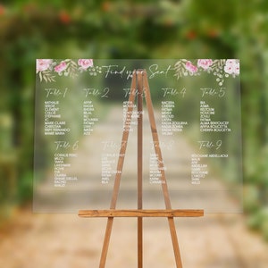 Könnte beinhalten: Ein transparenter Sitzplan aus Acryl mit einem floralen Design und dem Text "Find your Seat". Der Sitzplan listet die Namen der Gäste für jede Tischnummer von Tisch 1 bis Tisch 9 auf.