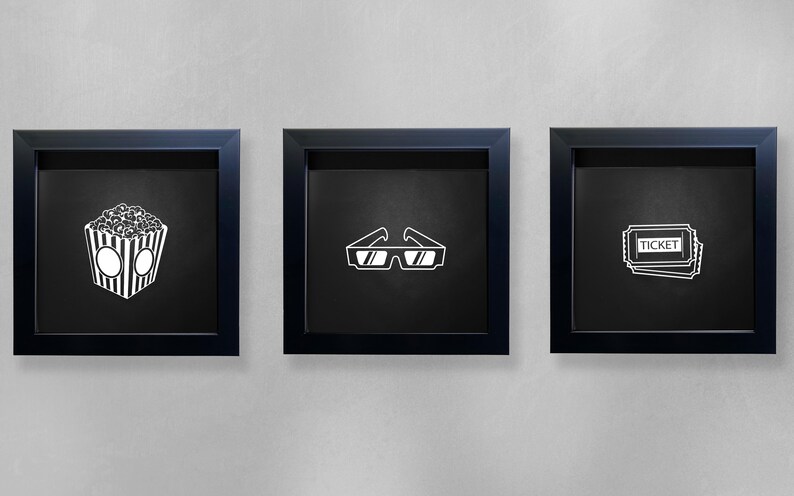 May include: Three black framed pictures on a white wall. The pictures each contain a white silhouette of a movie-related item. The first picture shows a bucket of popcorn. The second picture shows a pair of 3D glasses. The third picture shows a stack of movie tickets with the word "TICKET" printed on them.