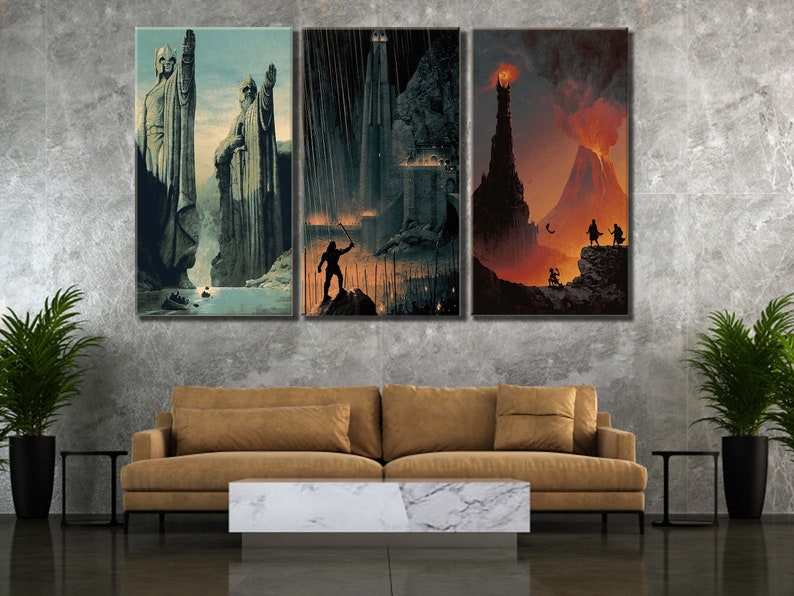 Op de afbeelding: Een driedelige wandkunstset met fantasielandschappen. Het linkerpaneel toont twee grote stenen beelden bij een rivier. Het middelste paneel toont een donker fort in de regen met een silhouet. Het rechterpaneel toont een vulkanische berg.