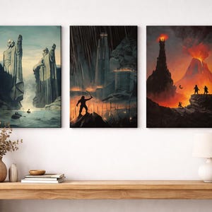 Op de afbeelding: Een set van drie verticale wandkunstprints met fantasielandschappen. Het linkerpaneel toont twee grote stenen beelden bij een rivier. Het middelste paneel toont een donker fort met een silhouetfiguur. Het rechterpaneel toont een vulkaan.