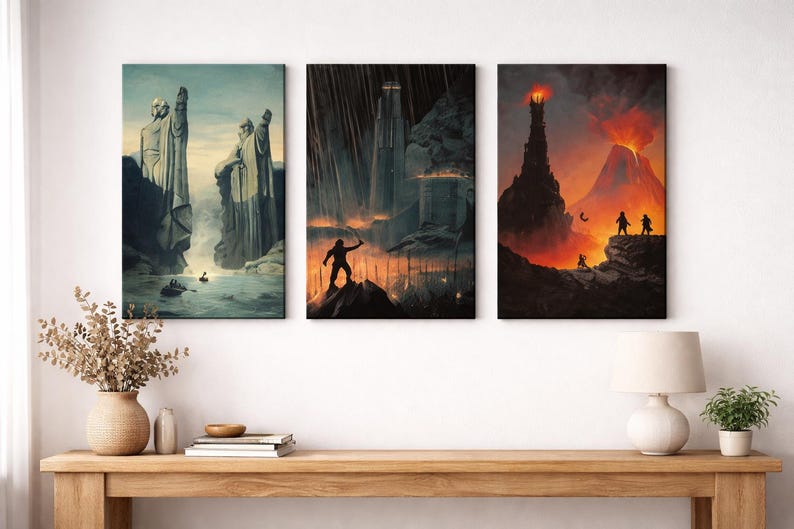 Op de afbeelding: Een set van drie verticale wandkunstprints met fantasielandschappen. Het linkerpaneel toont twee grote stenen beelden bij een rivier. Het middelste paneel toont een donker fort met een silhouetfiguur. Het rechterpaneel toont een vulkaan.