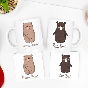 May include: Two white ceramic mugs and two square coasters with bear illustrations. One mug and coaster say "Mama Bear" with a light brown bear. The other mug and coaster say "Papa Bear" with a dark brown bear.