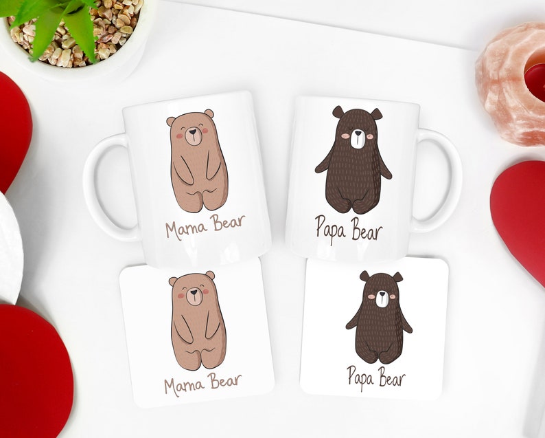 May include: Two white ceramic mugs and two square coasters with bear illustrations. One mug and coaster say "Mama Bear" with a light brown bear. The other mug and coaster say "Papa Bear" with a dark brown bear.
