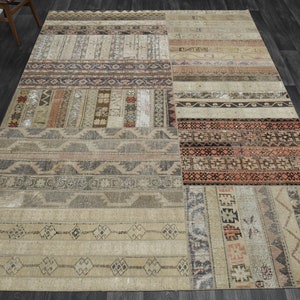 Könnte beinhalten: Ein beige-brauner Patchwork-Teppich mit geometrischen Mustern. Der Teppich besteht aus verschiedenen Stoffstücken, die zusammengenäht wurden.