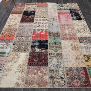 Könnte beinhalten: Ein rechteckiger Patchwork-Teppich mit einer Vielzahl von Mustern und Farben. Der Teppich besteht aus zahlreichen rechteckigen Flicken, jeder mit einem einzigartigen Design, darunter florale, geometrische und abstrakte Motive. Die Farbpalette umfasst Rot-, Grün-, Blau- und Cremetöne.