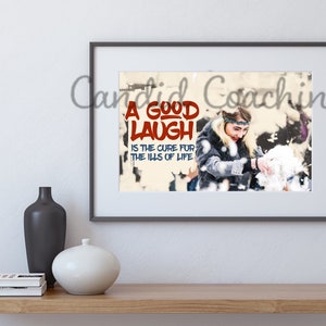 May include: A framed print with a woman laughing and throwing snow in the air. The print has the text "A good laugh is the cure for the ills of life" in red and blue letters.