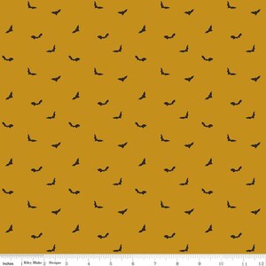 May include: Mustard-colored fabric with a repeating pattern of black bat silhouettes. The bats are scattered across the surface, creating a Halloween-themed design. The fabric is suitable for various craft projects.