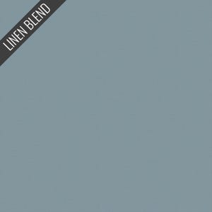 May include: A solid, muted blue-gray fabric with a subtle texture. The words "LINEN BLEND" are printed in white on a black diagonal banner in the upper left corner. The fabric appears to be a linen blend.