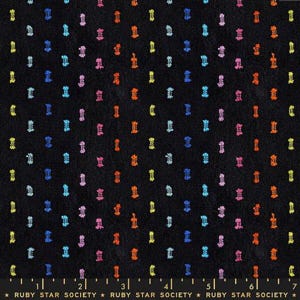 May include: Black fabric with a repeating pattern of colorful, stylized shapes in yellow, blue, pink, orange, and green. The shapes are evenly spaced across the fabric. The bottom of the image has a ruler and the text "RUBY STAR SOCIETY".