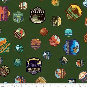 May include: Green fabric featuring a repeating pattern of colorful national park patches. The patches display various park names and illustrations, including Yosemite, Glacier, and Rocky Mountain. The design includes text such as "Grand Canyon" and "Great Smoky Mountains".