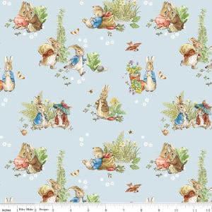 May include: Light blue fabric featuring a repeating pattern of bunnies in various poses, dressed in jackets and dresses. The bunnies are surrounded by flowers, butterflies, and other garden elements. The design is reminiscent of a children's book illustration.