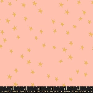 May include: A fabric with a repeating pattern of gold stars scattered across a light coral background. The stars are hand-drawn in a simple, whimsical style. The bottom of the fabric has the text "RUBY STAR SOCIETY".