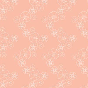 May include: A repeating pattern of white, stylized floral shapes on a peach-colored background. The design features various sizes of the floral elements, creating a visually dynamic and textured effect. The pattern is suitable for fabric or wallpaper.