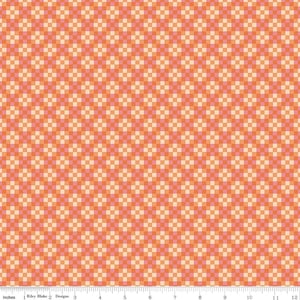 May include: A fabric with a repeating pattern of small, square blocks in shades of orange and cream. The design is evenly spaced, creating a textured appearance. The image includes a ruler with inch measurements.