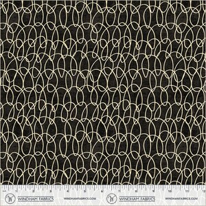 May include: Black fabric with a repeating pattern of cream-colored, interconnected oval shapes. The design creates a textured appearance. The bottom edge of the fabric shows a ruler with inch measurements. The Windham Fabrics logo is visible.